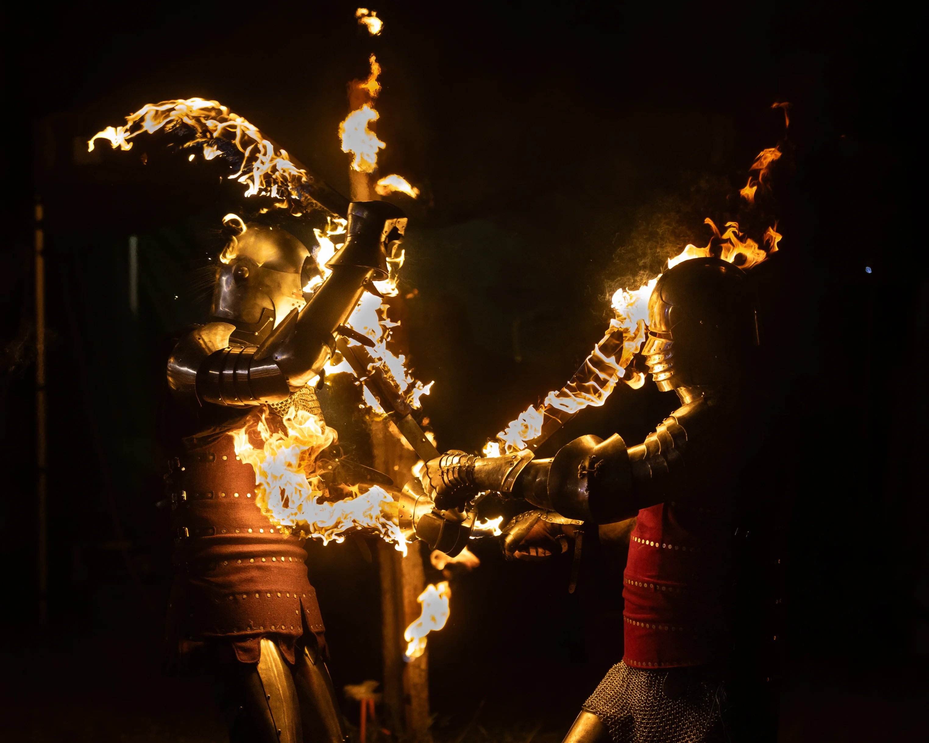 Armoured knights performing with flaming weapons