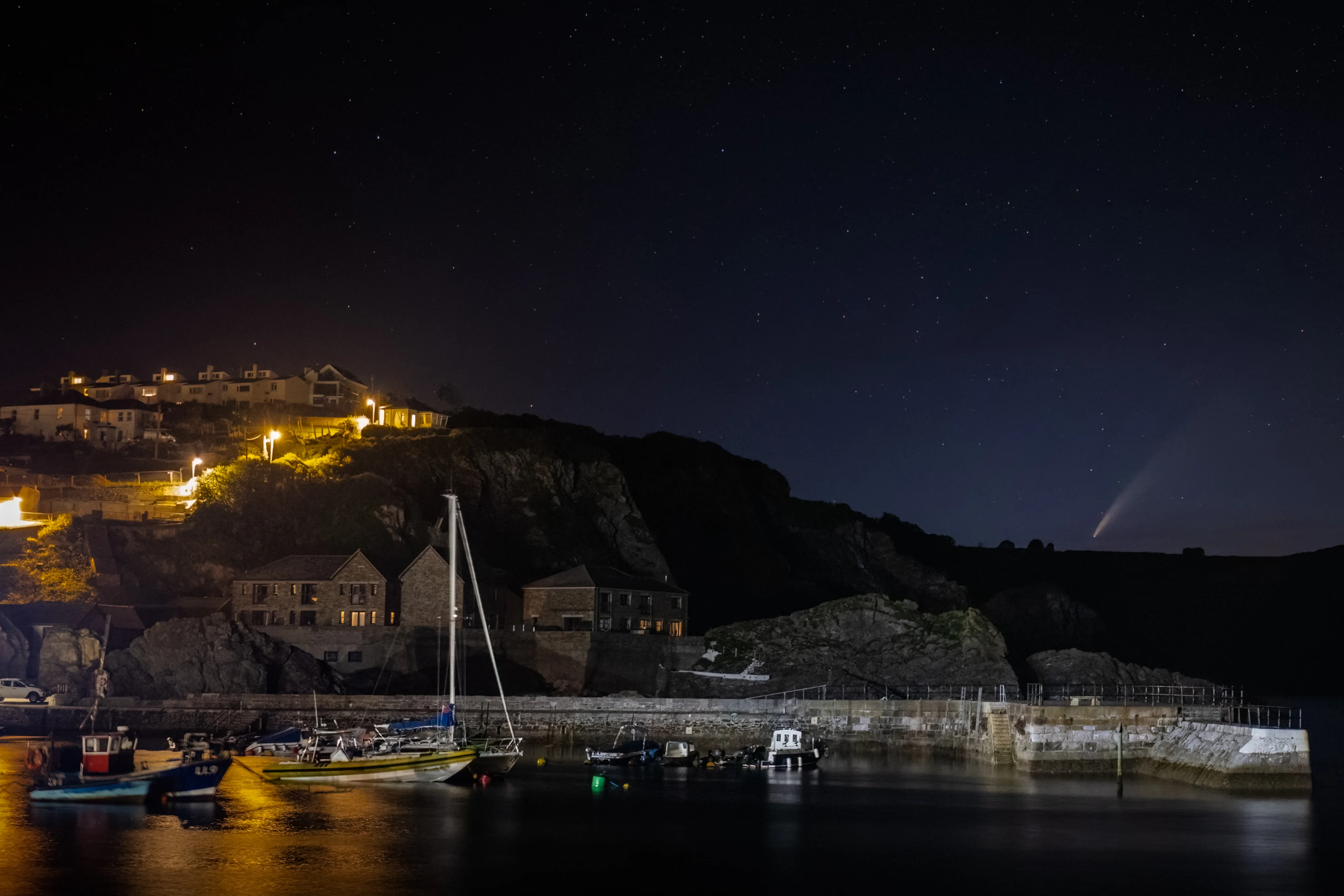 Coastal harbour illuminated against a dark night sky