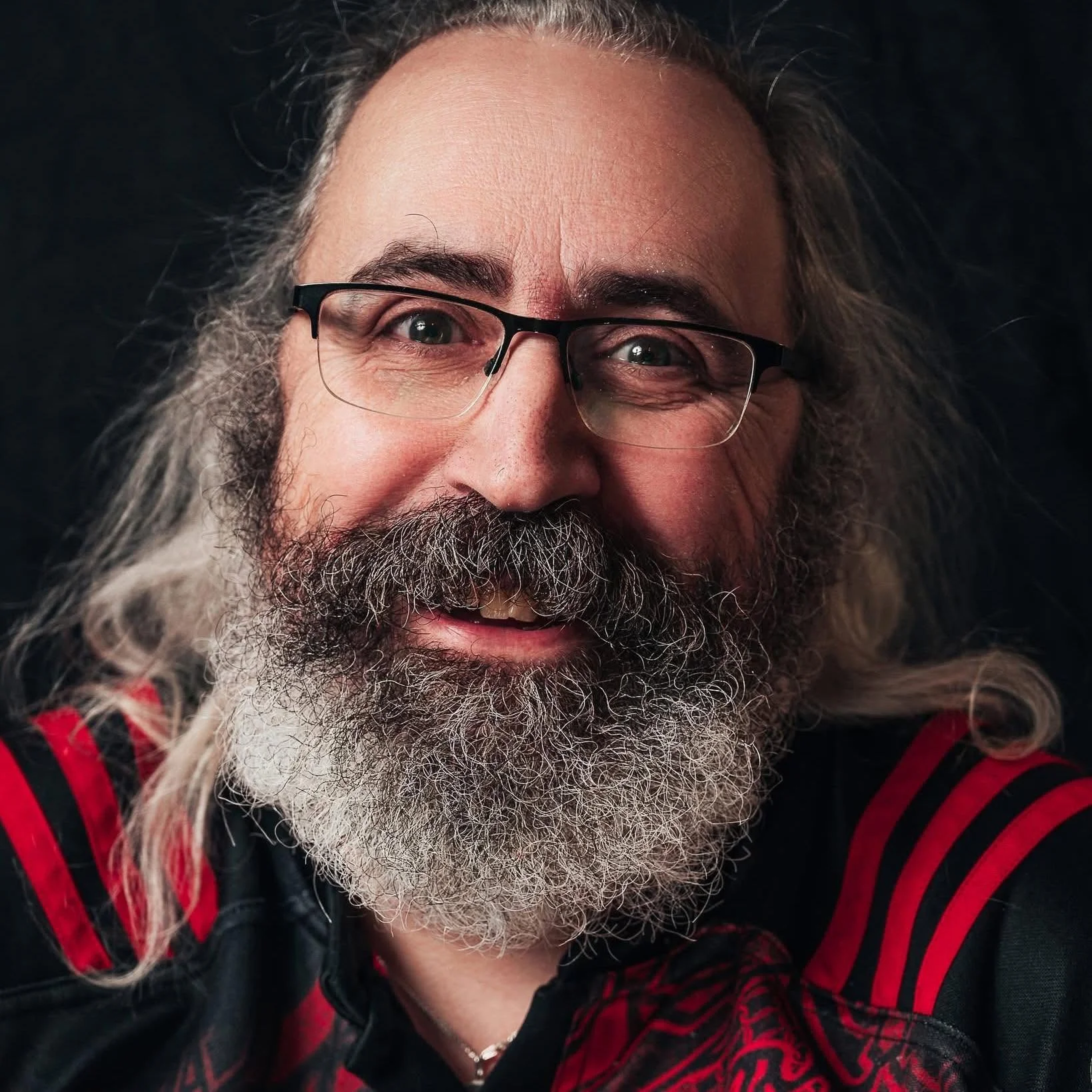 The photographer behind RWBJ Photography, smiling against a dark background